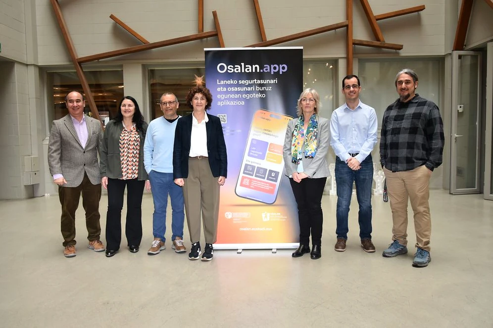 Grupo de personas posando frente a un banner de Osalan.app