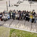 Grupo de personas posando en un espacio público al aire libre.