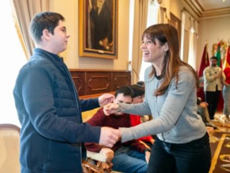 Dos personas sonrientes interactuando en un evento formal.