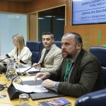 Tres personas en una mesa de debate en el Parlamento Vasco.