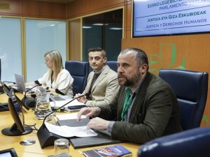 Tres personas en una mesa de debate en el Parlamento Vasco.