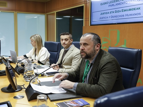 Tres personas en una mesa de debate en el Parlamento Vasco.