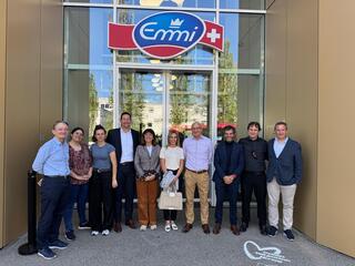 Grupo de personas frente a la entrada de Emmi en Suiza