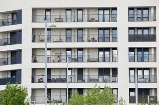 Fachada de un edificio moderno con balcones y plantas.