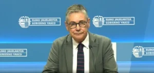 Hombre con gafas y chaqueta en conferencia de prensa