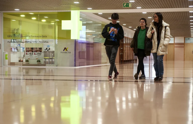 Tres estudiantes caminando por un pasillo de la EHU