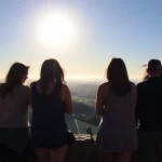 Cuatro personas observando un paisaje al atardecer