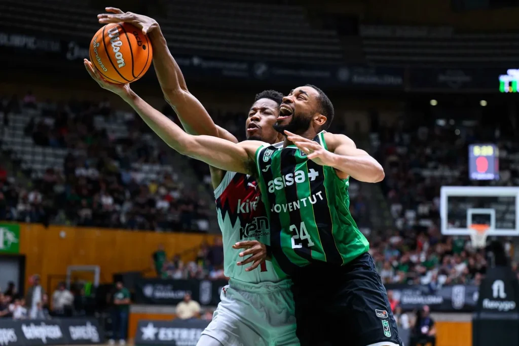 Jugador de Asisa Joventut lanza a canasta en un partido de baloncesto.