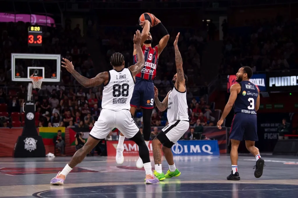 Jugador de Kosner Baskonia lanzando a canasta en un partido de baloncesto.