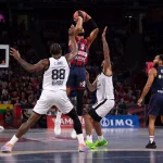Jugador de Kosner Baskonia lanzando a canasta en un partido de baloncesto.