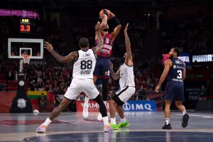 Jugador de Kosner Baskonia lanzando a canasta en un partido de baloncesto.