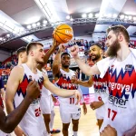 Jugadores de Kosner Baskonia celebrando en la cancha de baloncesto.
