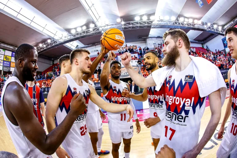 Jugadores de Kosner Baskonia celebrando en la cancha de baloncesto.
