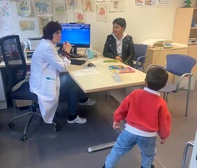 Consulta médica con un niño y una doctora en un consultorio.