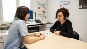 Dos mujeres conversan en una oficina sobre donación de médula ósea.