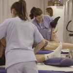 Fisioterapeutas asistiendo a pacientes en una sesión de rehabilitación