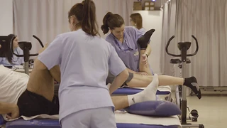 Fisioterapeutas asistiendo a pacientes en una sesión de rehabilitación