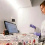 Mujer organizando pastilleros personalizados en una mesa