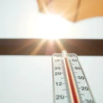 Termómetro mostrando temperaturas altas bajo el sol