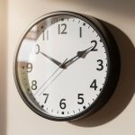 Reloj de pared con manecillas en la hora dos y cinco.