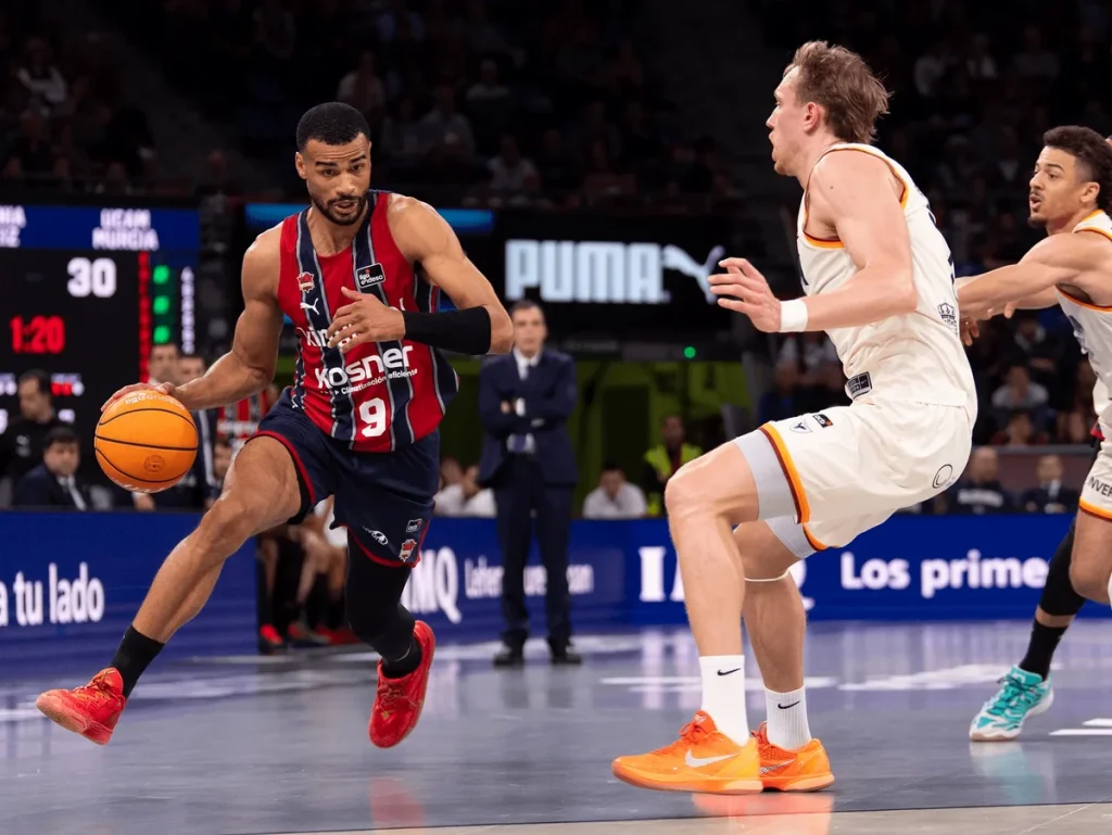 Jugador de Baskonia driblando el balón en un partido de baloncesto