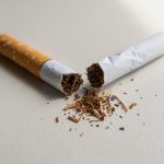 Cigarrillos rotos con tabaco esparcido sobre una mesa.