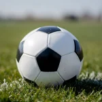 Balón de fútbol sobre un campo de hierba verde