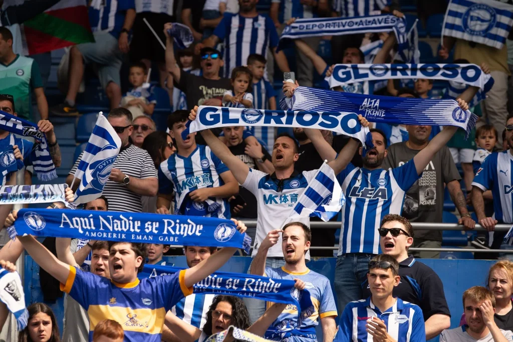 Aficionados del Alavés animando con bufandas en el estadio