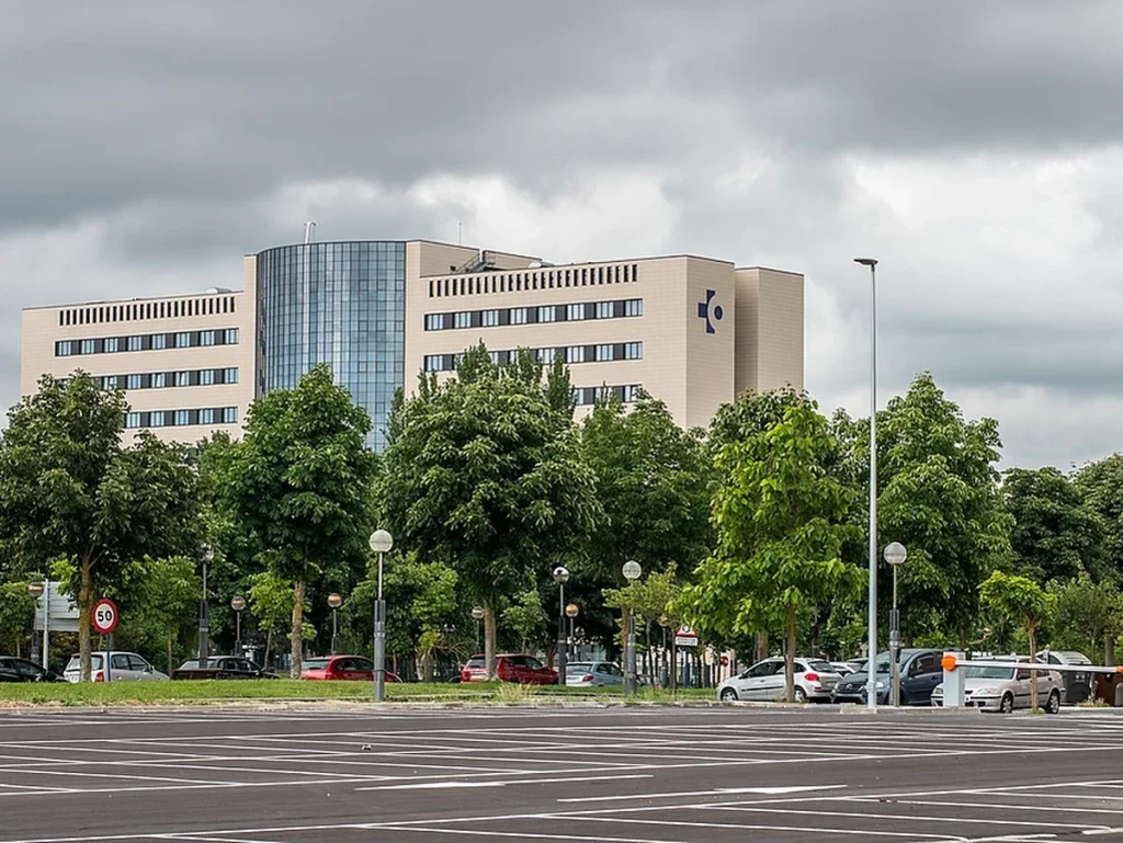 Edificio del Hospital Txagorritxu rodeado de árboles y coches.