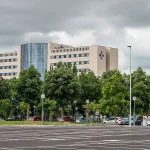Edificio del Hospital Txagorritxu rodeado de árboles y coches.