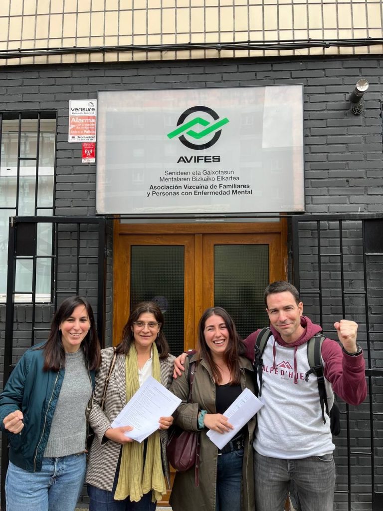 Cuatro personas posan frente a la sede de Avifes con documentos en mano.