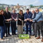 Grupo de personas sosteniendo verdel en un puerto pesquero de Euskadi.