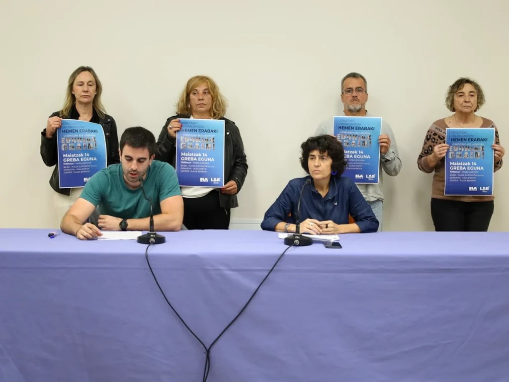 Grupo de personas sosteniendo carteles en una conferencia de prensa.