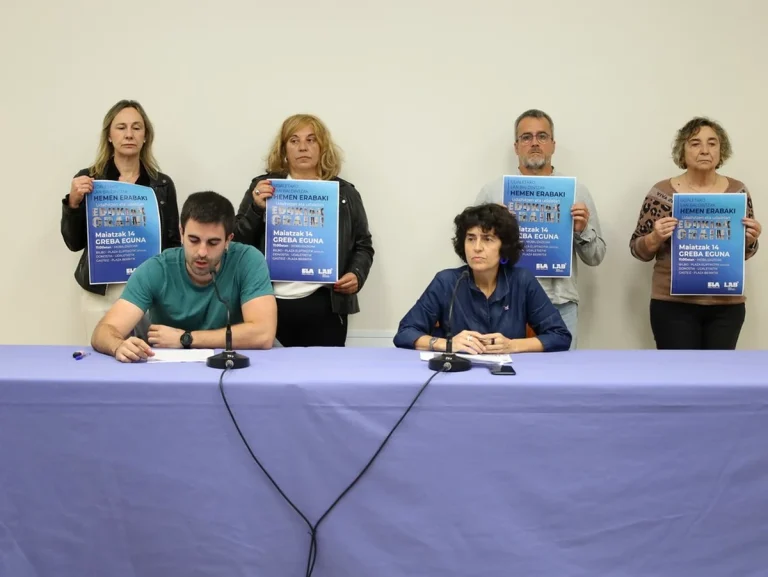 Grupo de personas sosteniendo carteles en una conferencia de prensa.