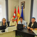 Reunión en el Ayuntamiento de Iruña de Oca con cuatro personas y banderas