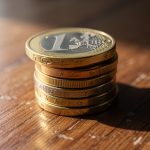 Monedas de euro apiladas sobre una superficie de madera