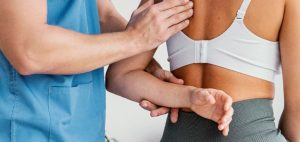 Fisioterapeuta asistiendo a paciente en tratamiento