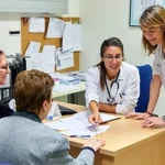 Médicos y pacientes interactuando en una consulta médica
