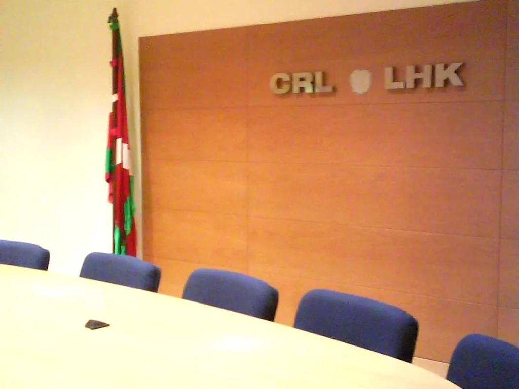 Sala de reuniones con bandera vasca y mesa ovalada