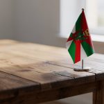 Pequeña bandera del País Vasco sobre una mesa de madera