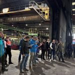 Grupo de trabajadores reunidos en una fábrica durante una asamblea