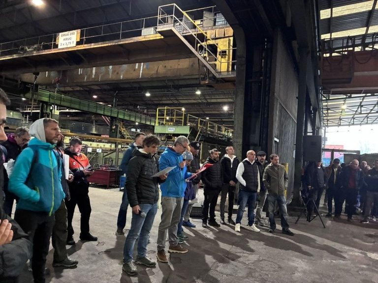 Grupo de trabajadores reunidos en una fábrica durante una asamblea