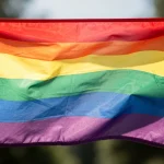 Bandera arcoíris ondeando al viento en un evento LGBTI+