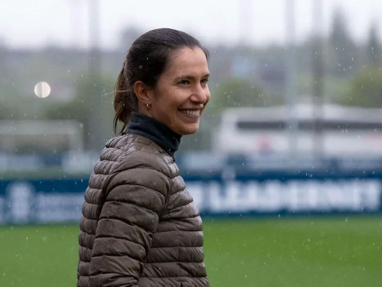 Entrenadora en un campo de fútbol bajo la lluvia