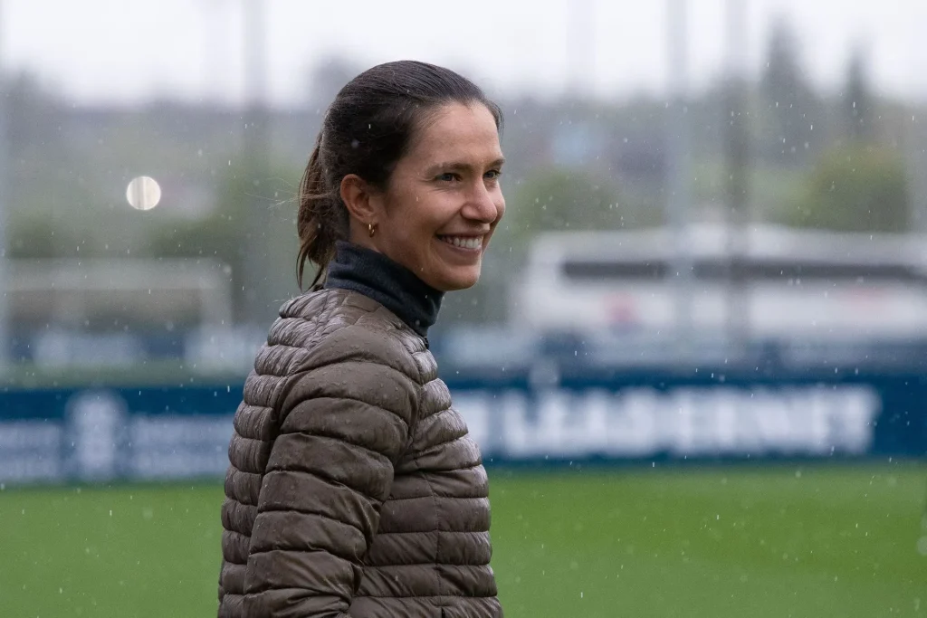Entrenadora en un campo de fútbol bajo la lluvia
