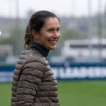 Entrenadora en un campo de fútbol bajo la lluvia
