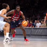 Jugador de baloncesto driblando en un partido de playoff