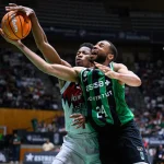 Jugadores de baloncesto compiten por el balón en un partido.