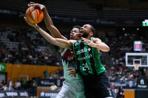 Jugadores de baloncesto compiten por el balón en un partido.
