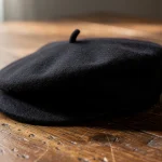 Gorra negra sobre una mesa de madera clara